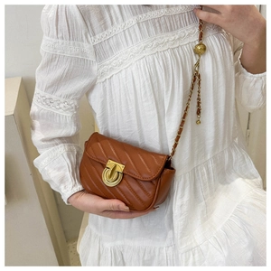 Detail view of brown quilted leather crossbody bag with gold twist lock and chain strap