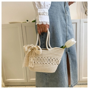 Detail of cream knit tote bag with 3D wavy texture and a large lace bow on the side