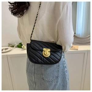 Detail of black quilted leather crossbody bag with gold twist lock and chain strap