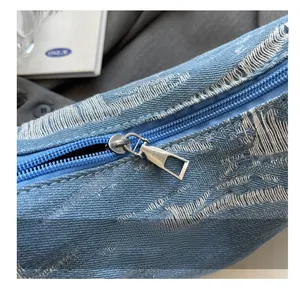 Close-up of blue denim bag with jacquard texture and silver metal zipper pull detail