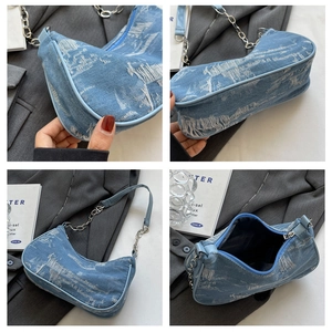 Detail view of denim underarm bag with distressed texture and silver chain strap