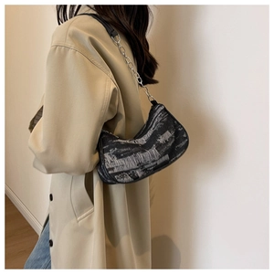 Détail du motif abstrait noir et blanc sur ce sac à bandoulière demi-lune très élégant