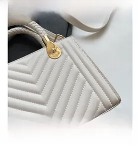 Close-up of white quilted leather texture and woven handle on this luxury handbag