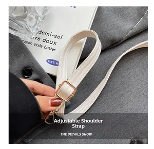 Detail view of the adjustable cream white PU leather strap with golden metal buckles