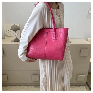 Close-up of fuchsia tote bag with crocodile texture and high-quality leather finish