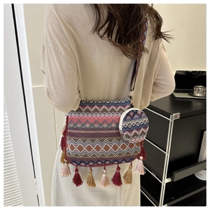 Détail d'un sac bandoulière tissé bohème avec pompons colorés et petit porte-monnaie assorti