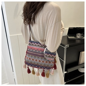 Détail d'un sac bandoulière tissé bohème avec motifs géométriques et glands à franges