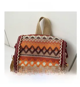 Close-up of ethnic woven backpack featuring colorful geometric patterns and side tassels