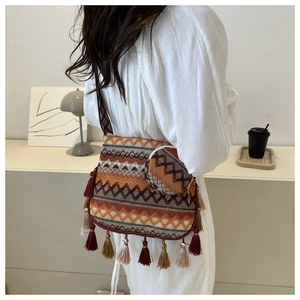 Détail d'un sac bandoulière tissé bohème avec motifs géométriques et longues franges