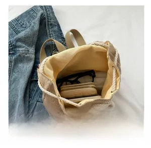 Capacity view of ethnic canvas drawstring backpack holding wallet, sunglasses and phone