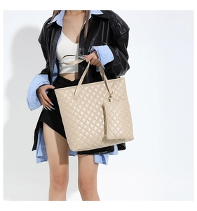Gros plan sur le sac fourre-tout beige matelassé avec une pochette assortie et surpiqûres