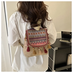 Détail d'un sac à dos ethnique en toile avec motifs tissés colorés et longues franges