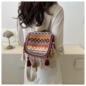 Détail du sac à dos bohème avec motifs géométriques tissés et pompons multicolores