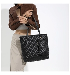 Détail du sac cabas matelassé noir avec pochette amovible assortie sur le mannequin