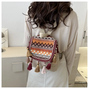 Close-up of bohemian backpack with ethnic geometric embroidery and colorful long tassels