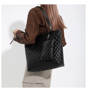 Gros plan d'un sac cabas en cuir matelassé noir avec mini pochette sur un modèle féminin