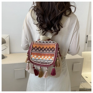 Ethnic woven backpack with geometric embroidery and colorful tassels on the flap