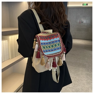 Close-up of bohemian woven backpack with colorful tassels and ethnic wave patterns
