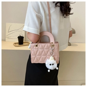 Pink quilted crossbody bag detail with cute white plush monster charm accessory