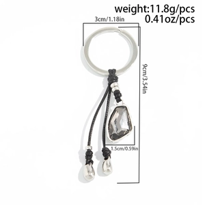 Detail of luxury heart keychain featuring grey faceted gemstone and dimensions of 9cm length