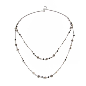 Bohemian vintage layered necklace with metallic flower charms and mixed beads on white