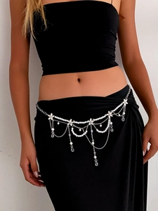 Detail of layered pearl belly chain with crystal flowers and silver fringe on a model