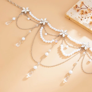 Detailed shot of layered pearl fringe waist chain with crystal flower and teardrop pendants