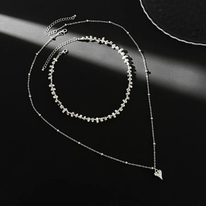 Détail artistique du pendentif coeur argenté et du collier double épaisseur à perles