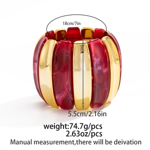 Macro detail of elastic bangle with wide gold metal and red marble texture segments