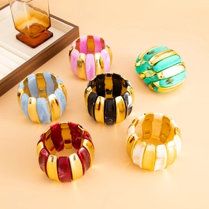 Detail of colorful acrylic and gold stretch bracelet set with multi-colored marble textures