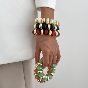 Ensemble de bracelets en perles de résine CCB colorées avec accents dorés sur un poignet