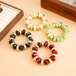 Détail de quatre bracelets en perles de résine colorées avec accents en métal doré