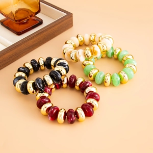 Détail de bracelets bohèmes en résine et maillons CCB dorés en blanc marbre, vert et bordeaux