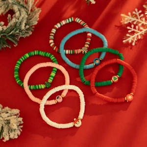 Détails de bracelets de Noël élastiques avec breloques festives sur fond rouge