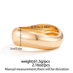Detail of wide wavy gold bangle with dimensions 6.3cm diameter and 3cm width measurements