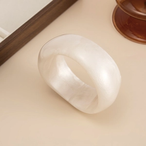 Detailed macro view of wide pearl white acrylic resin bangle with iridescent marbling