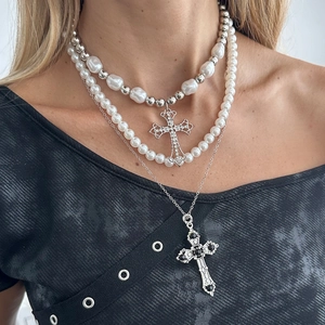Macro shot of triple-layer gothic necklace with baroque pearls and cross pendants