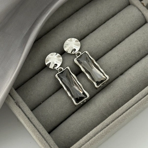 Detail shot of silver rectangular drop earrings with dark grey step-cut crystals