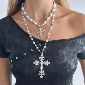 Detail view of double-layered cross necklaces with faux pearls and sparkling rhinestones