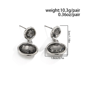 Detailed view of silver double-layered oval earrings with grey faceted crystals