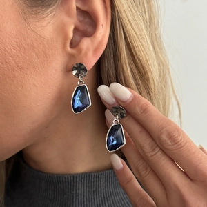 Detail of dark blue geometric crystal drop earrings on model showcasing elegant fit