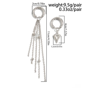 Vue détaillée de boucles d'oreilles asymétriques avec longues chaînes et pendentif cœur