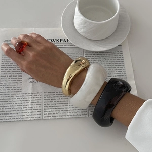 Irregular resin and metal bangles set in gold, marble white, and amber for women