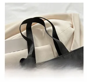 Detail of comfortable black mesh tote bag handle with reinforced nylon stitching