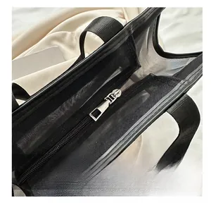 Close-up of durable mesh tote bag featuring smooth silver metal zipper and nylon handles