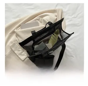 Macro view of large mesh tote bag showing spacious interior with wallet and umbrella
