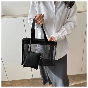 Detail of black mesh tote bag with NOIEY PARIS SONG text and small inner pouch