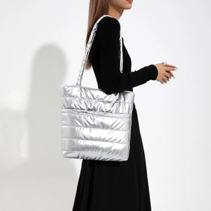 Silver quilted tote bag with metallic finish for women, spacious shoulder bag on model