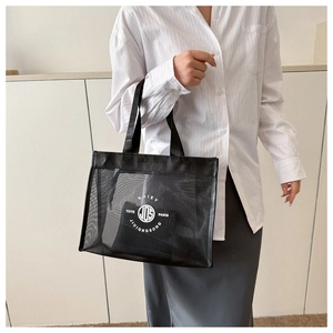 Detail of black mesh tote bag showing the inner pouch with circular logo and lettering