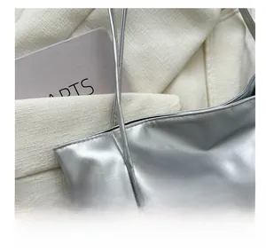 Detailed close-up of metallic silver tote bag featuring high-quality faux leather stitching